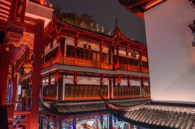 Shanghais 'in eski kasabasında geleneksel bir Çin binası. Karmaşık ahşap oymalar, kırmızı aksanlar ve altüst olmuş saçaklar var. Geceleri aydınlatılıyor..