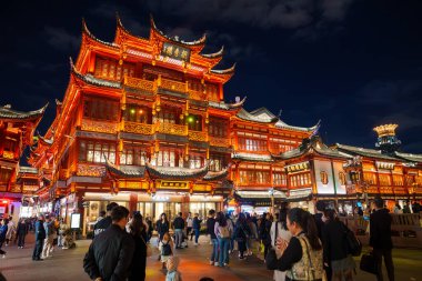 Çin 'in Şangay kentindeki Yuyuan Eski Caddesi geceleri aydınlanıyor. Geleneksel Çin mimarisini ahşap oymalar ve kırmızı fenerlerle sergiliyor..