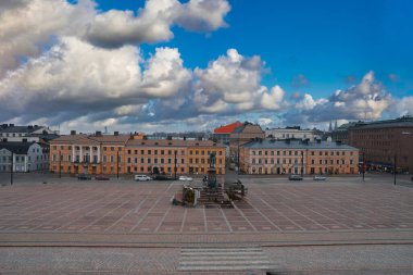 Finlandiya 'nın Helsinki kentindeki Senato Meydanı' nda, dramatik bulutların altındaki Hükümet Sarayı gibi neoklasik binalarla çevrili II. Alexander heykeli yer almaktadır..