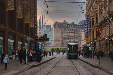 4 numaralı yeşil tramvay Finlandiya, Helsinki 'de kaldırım taşları üzerinde seyahat eder. Tarihi binalar ve şenlikli ışıklar canlı bir şehir atmosferi yaratıyor..