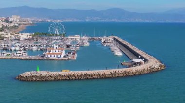 Benalmadena 'nın yat, yıkanmış binalar, yüksek şehir binaları, yemyeşil alanlar ve İspanya' daki uzak dağların havadan görünüşü..