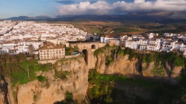 İspanya 'nın Ronda kentinin havadan görünüşü, El Tajo geçidi üzerindeki Puente Nuevo köprüsünün görüntüsü, Endülüs mimarisi ve günbatımı aydınlatma tepeleri.