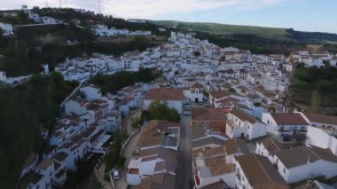 Setenil De Las Bodegas, İspanya 'nın hava perspektifi, kayalıklarda beyazlatılmış binalar, dolambaçlı bir yol ve yemyeşil.