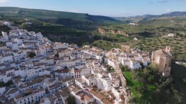 Setenil De Las Bodegas, İspanya 'nın hava perspektifi kayalıklara kurulmuş, yuvarlak tepeler ve yemyeşil alanlarla çevrili beyaz boyalı binaları sergiliyor..