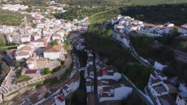 Setenil De Las Bodegas 'ı, uçurum kenarındaki mimari ve zemin kattaki beyazlatılmış binaların ve yemyeşil manzaraların havadan görüntüleriyle keşfedin..
