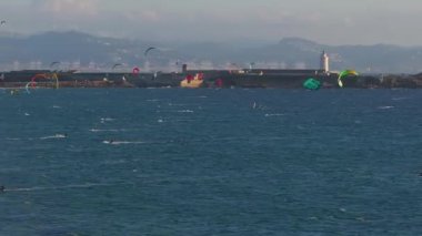 İspanya 'daki Tarifa plajında renkli uçurtmalar, kasaba binaları ve Fas Boğazı bulunur..