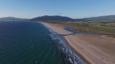 Atlantik Okyanusu 'nun kumlu kıyılarla buluştuğu Tarifa' nın sahil şeridinin havadan görünüşü. Cebelitarık Boğazı ve Fas 'ın dış hatları su üzerinde görülebiliyor..