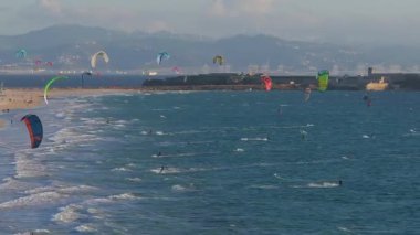 Tarifa 'nın kıyı kasabasında Atlantik Okyanusu' nda uçurtma sörfçüleri, Cebelitarık Boğazı ve Fas manzarası ve arka planda rüzgar türbinleri bulunur..