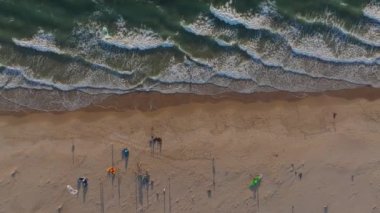 Tarifa sahilinin şemsiyeli ve kıyı şeritli havadan görüntüsü. Fas kıyıları Cebelitarık Boğazı boyunca görünür, iki kıtayı birbirine bağlıyor..