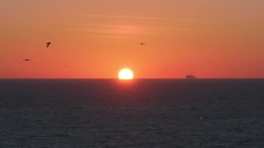 Güneş Atlantik Okyanusu 'nun üzerinde Cebelitarık Boğazı' nda batıyor. Gökyüzüne karşı silueti olan bir gemi ve Fas kıyıları uzaktan görülebiliyor..