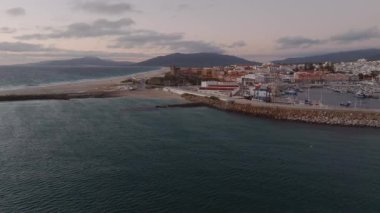 İspanya, Tarifa 'nın havadan görünüşü, kumsalını, kırmızı kiremitli çatılarını ve dağlarını gösteriyor. Arka planda Cebelitarık ve Fas Boğazı görünüyor..