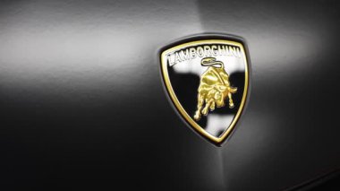 Lamborghini Urus 'un ayrıntılı manzarası, amblem ve parlak bitiş üzerine odaklanarak, aracın lüks tasarımı ve işçiliğinin altını çiziyor.