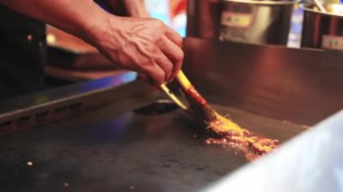 Bir satıcı, canlı bir Şangay pazarının ortasında ahtapotu şiş kebap yapıp canlı sokak yemekleri ve mutfak kültürünü yakalıyor..