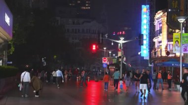 Geceleri neon ışıkları, karışık mimari ve hareketli kalabalıklarla dolu canlı bir Şangay caddesi şehrin dinamik gece hayatı atmosferini yakalıyor..