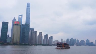 Şangay 'ın ikonik silueti, Şangay Kulesi, Dünya Finans Merkezi ve nehirde bulutlu bir gökyüzünün altında geleneksel bir tekne..