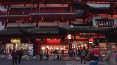 Video, Şangay 'ın Yu Gardens bölgesindeki hareketli aktiviteleri gösteriyor. Geleneksel Çin mimarisini ve yerel dükkanların keyfini çıkaran neşeli kalabalığı vurguluyor..