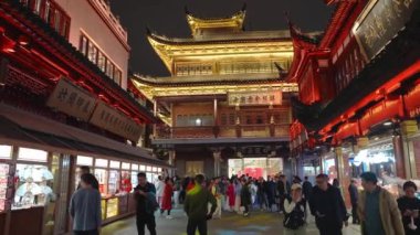 Şangay 'daki Yu Gardens altın ışıklarla aydınlanıyor, geleneksel Çin mimarisini gözler önüne seriyor ve hareketli bölgeyi keşfeden kalabalık..