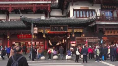 Şangay 'daki Yu Gardens' ta geleneksel Çin mimarisi, karmaşık oymalar ve yerli halk ve turist kalabalığıyla dolu canlı bir tabela yer alıyor..