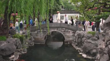 Şangay 'daki Yu Gardens gölün üzerinde taştan bir köprü, yemyeşil bir yer ve klasik Çin mimarisi barındırıyor..