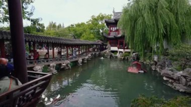Şangay 'daki Yu Gardens' ta geleneksel mimari, koi havuzları, yemyeşil alanlar ve manzaralı yolları ve kültürel mirası seven ziyaretçiler yer alıyor..