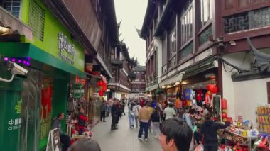 Şangay 'ın Yu Gardens bölgesinde canlı bir cadde. Geleneksel Çin mimarisi, çeşitli kalabalıklar ve hareketli pazar tezgahları sergileniyor..
