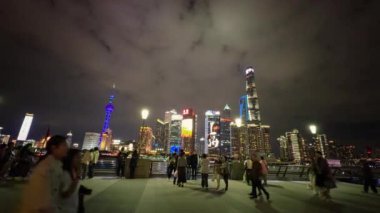 Video, Şangay 'ın Bund' ını gece çekerken, aydınlık Doğu İnci Kulesi ve Şangay Kulesi 'nin gösteriminde, insanlar canlı gezintinin keyfini çıkarıyorlar..