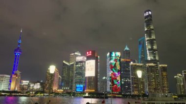 Gece Shanghai siluetinde aydınlık Doğu İnci Kulesi, Şangay Kulesi ve Huangpu Nehri 'ni yansıtan diğer gökdelenler sergileniyor..