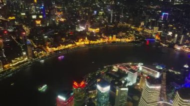Şangay 'ın canlı gece şehri Huangpu Nehri boyunca aydınlatılmış Doğu İnci Kulesi ve tarihi Bund binalarıyla.