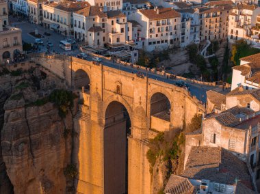 Puente Nuevo köprüsü gün batımında İspanya 'nın Ronda şehrinde derin bir vadi boyunca uzanır. Geleneksel İspanyol mimarisi kent simgesini çevreleyerek dramatik yapısını vurguluyor.