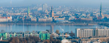 St. Peter Kilisesi, Riga Katedrali ve Daugava Nehri 'nin yer aldığı Riga, Letonya' nın hava manzarası. Zafer Parkı 'nda modern binalar ve dönme dolap görülebilir.