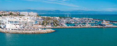 Benalmadena, İspanya 'nın hava perspektifi, yatları, dönme dolabı, beyaz Akdeniz binaları ve uzak dağları olan canlı bir marinayı vurguluyor..
