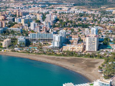 İspanya 'nın Benalmadena kentinin havadan görünüşü, kumlu bir plaj, turkuaz sular ve kıyı şeridi boyunca modern ve geleneksel mimarinin bir karışımını sergiliyor..