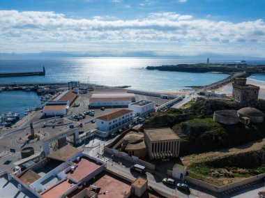 Tarifa, İspanya 'nın havadan görünüşü, kayalık bir tepede bir kale, modern ve tarihi bir mimari, ve arka planda parıldayan bir okyanus..