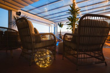 Pofuduk yastıklı hasır sandalyeler cam bir tavanın altında parlayan bir kürenin etrafını sarıyor. Saksı bitkileri bu butik otel ortamındaki dingin atmosferi arttırır..
