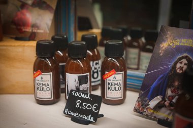 Small bottles labeled Don Enrique's Kema Kulo are displayed with a price tag of 8.50EUR for 100ml, accompanied by an artistic card in a boutique shop. clipart