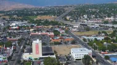 Reno, Nevada 'nın şehir manzarası yukarıdan görülüyor. Arka planda yollar, otoyollar ve Sierra Nevada dağları var..