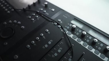 Ses karıştırma konsolundaki faders ve düğmelerin detaylı görüntüsü, Los Angeles 'taki bir stüdyoda ses mühendisliğinin hassasiyetini ve karmaşıklığını gözler önüne seriyor.