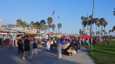 Los Angeles 'taki Venice Beach' te satıcılarla, renkli tezgahlarla ve Kaliforniya 'nın özünü yansıtan ikonik palmiye ağaçlarıyla dolu canlı bir sahil yolu bulunuyor..