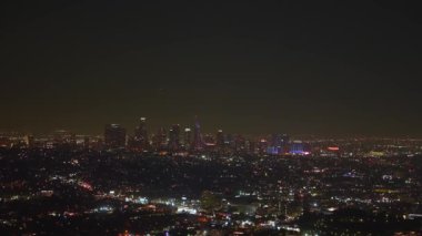 Los Angeles gökdelenleri ve karanlık gökyüzüne karşı canlı şehir ışıkları sergilenerek geceleri gökyüzü aydınlanıyor..