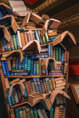 Books are creatively arranged in a sculpture at The Last Bookstore, Los Angeles. Vibrant spines and open pages contrast with the ornate ceiling. clipart