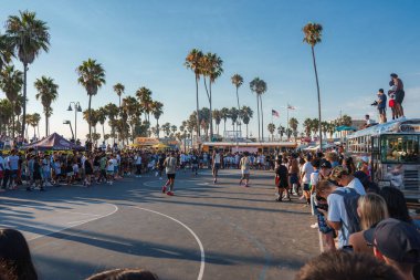Venedik Plajı, Los Angeles 'ta canlı bir sahne, açık bir gökyüzünün altında canlı bir kalabalık, palmiye ağaçları ve yemek kamyonlarıyla çevrili bir basketbol maçına ev sahipliği yapıyor..