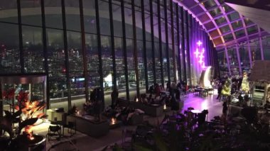 Londra 'nın aydınlık şehir manzarası Sky Garden' dan, ziyaretçiler iç mekanlar ve modern oturma düzenleri arasında dinleniyor..