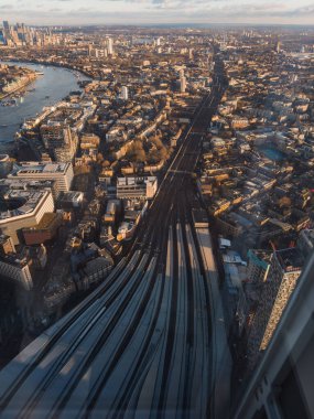 Londra 'nın Thames Nehri, Londra Köprüsü İstasyonu' na giden tren yolları ve Çömlek 'in ılık kış ışığında gölgesinin yer aldığı hava perspektifi..