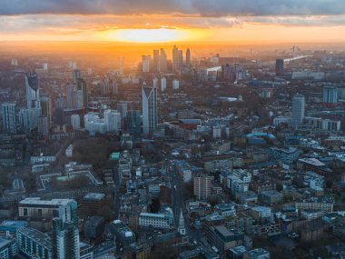 Görüntü günbatımında Londra 'nın ufuk çizgisini gösteriyor, The Shard ve Thames nehri yer alıyor. Şehir manzarası altın ışıkla aydınlanır..