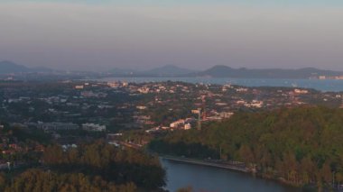 Tayland 'daki Phuket Adası' nın havadan görünüşü, yeşil tepeler, modern tatil beldeleri ve Andaman Denizi ile uzak adalar..