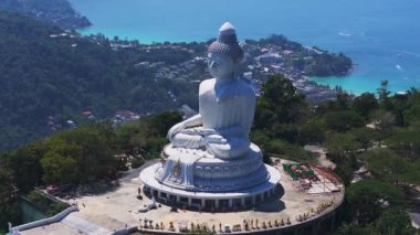 Tayland 'ın Phuket kentindeki Büyük Buda heykelinin havadan görünüşü yeşillikler, altın heykeller ve manzaralı ormanlar ve dağınık binalarla çevrili..
