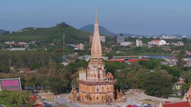 Phuket, Tayland 'daki Wat Chalong' un havadan görünüşü, altın kulesi, süslü mimarisi, yemyeşil, market tezgahları ve uzak tepeleriyle birlikte..