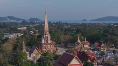 Phuket, Tayland 'daki Wat Chalong tapınak kompleksinin havadan görünüşü yeşillik, kentsel alanlar ve uzak adaları olan Andaman Denizi ile çevrilidir..