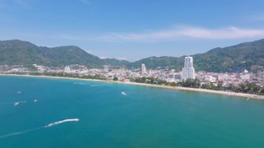Tayland, Phuket Adası 'nın havadan görünüşü Patong Sahili' ni, canlı mavi suları, yemyeşil tepeleri, tekneleri ve hareketli bir kıyı kasabasını gösteriyor..