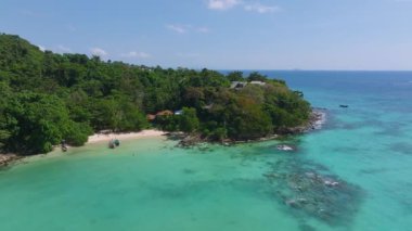 Tayland 'daki Phi Phi Adası' nın havadan görünüşü orman yarımadası, kumlu plajlar, kayalık sahil şeridi ve geleneksel uzun kuyruk teknesi sergileniyor..